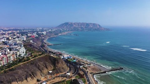 Aerial view of Lima's shoreline including the districts of Barranco and Chorrillos, with "Morro Solar" on the background. Clear and bright day, travel and destinations concept.