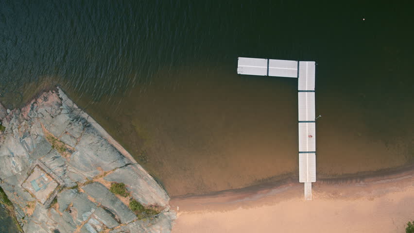 Aerial plan view shot of a young woman diving into a lake