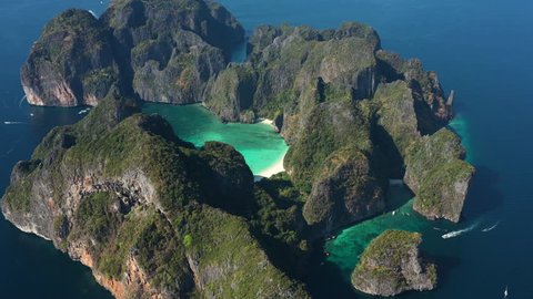 View from above, stunning aerial view of Koh Phi Phi Leh (Phi Phi Island) with the beautiful Maya Bay. A turquoise and clear water bathes a white beach surrounded by limestone mountain.