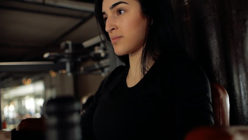 close-up face of Caucasian brunette girl shakes her abdominal muscles with her hands on the horizontal bar. athlete engaged in a fitness club. healthy lifestyle