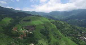 Aerial video in an amazing asian landscape, with drone, above rice terraces and small village in a beautiful day.