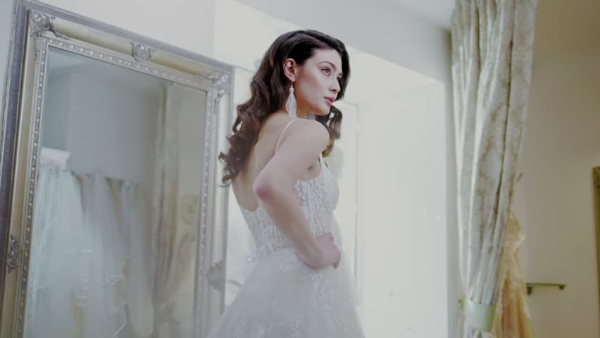 Beautifu bride choosing wedding dress in a wedding salon