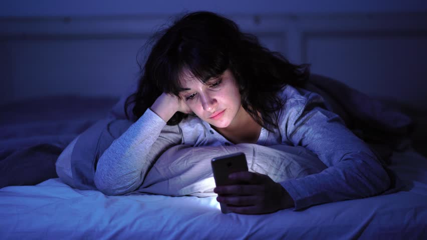 4K wide video of an Addicted young woman chatting and surfing on the internet using smart phone sleepy, bored and tired late at night. Dramatic dark light. In Internet, Mobile addiction and insomnia. Royalty-Free Stock Footage #1025524487