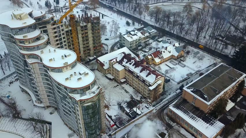 Ivano-Frankivsk, Ukraine - February 2, 2019: Aerial view of high modern residential building and tower crane under construction. | Shutterstock HD Video #1025527076