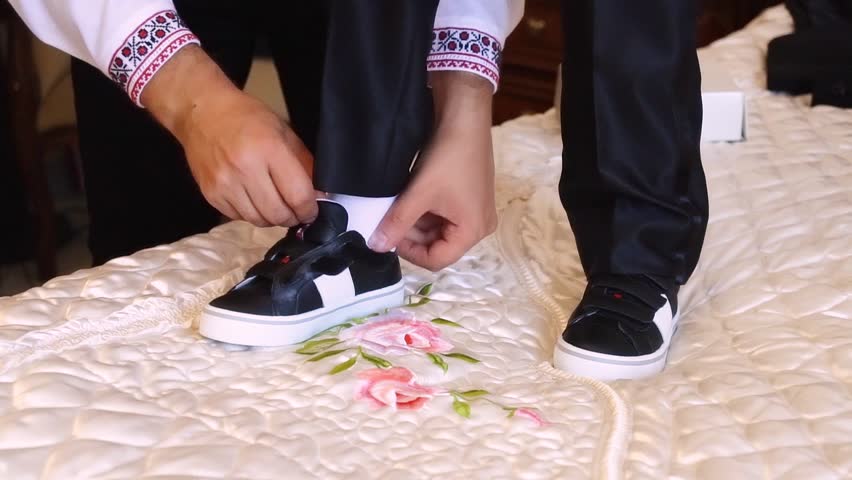 Father helping son to put on sport shoes