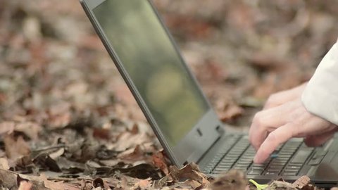 Typing on a laptop outside