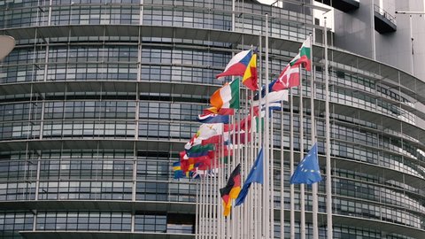 Slow motion flags of the European Union and Germany hoisted half-mast during the European obsequies for the former German Chancellor Helmut Kohl at European Parliament