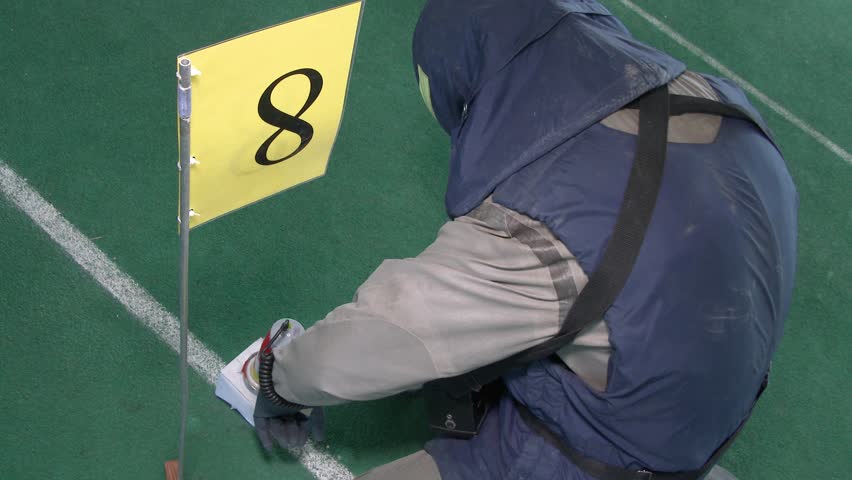 Man in hazmat outfit taking things for laboratory in abandoned factory. Indoors.