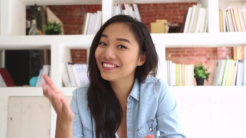 Happy asian teen girl student looking at camera webcamera making video call to distant friend or online teaching, smiling female teacher coach vlogger recording vlog speaking at webcam Royalty-Free Stock Footage #1025576939