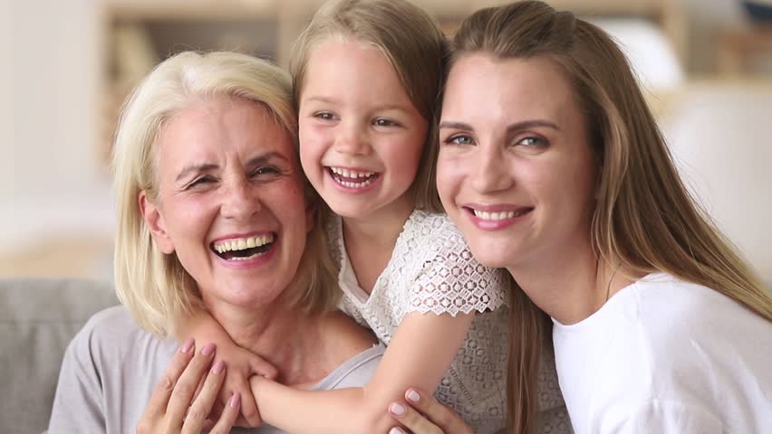 Three generations women happy family old grandmother, young daughter and child girl having fun embracing cuddling, smiling loving kid granddaughter mother grandma laughing hugging together at home Royalty-Free Stock Footage #1025576969