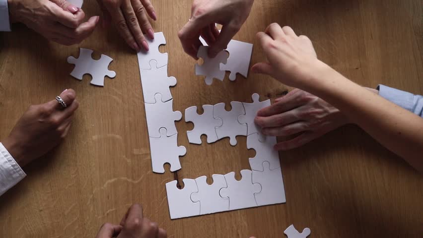 Hands of diverse business team people collaborate assemble puzzle together connect pieces at desk find common purpose solution engaged in help support contribute in teamwork concept top close up view
 Royalty-Free Stock Footage #1025577008