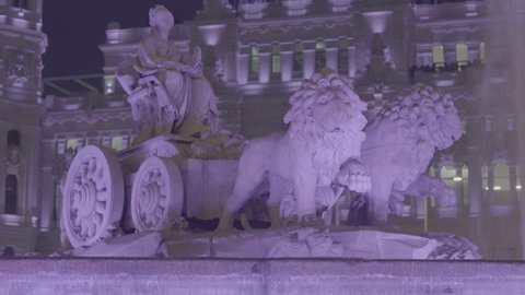 Night view of the Cibeles font in Madrid during woman's day and  the "Palacio de Comunicaciones" behind.