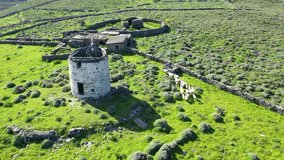 Aerial drone video of picturesque windmill in island of Kythnos overlooking the Aegean sea, Cyclades, Greece