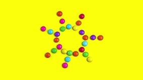 4K video of colorful chocolade smarties. They are changing in the sun and dancing. Then creates other shapes - circle, smile, lines.