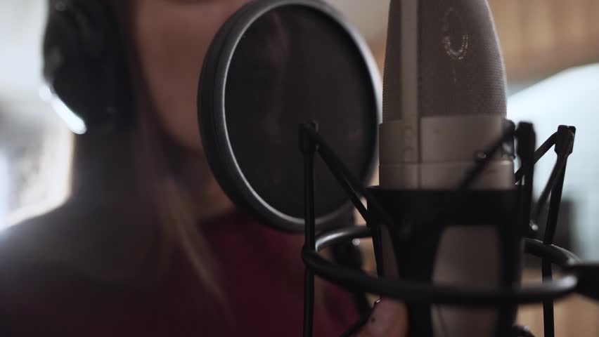 beautiful girl singing in a recording studio