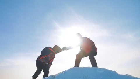 teamwork business concept victory help hands arm slow motion video. team group tourist hikers gives a helping hand. success win winter reached the top of the mountain. tourists climbers climb to the