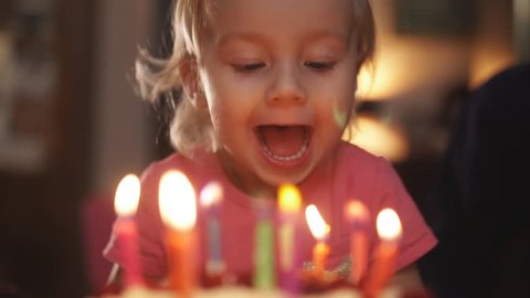 Happy little girl blowing birthday candles. Happy birthday