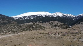 Aerial drone video of famous plateau of snowed Parnassus mountain at spring, Greece