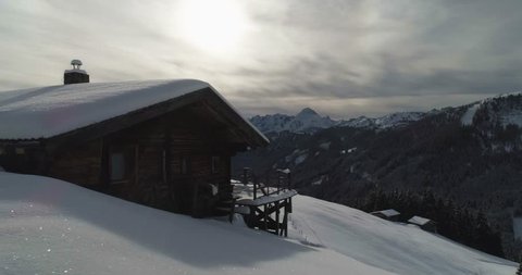 Person walks out from cabin to see winter time view across Austrian Alps. Huge mountain range in Mayrhofen