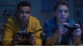 Emotional multiracial male friends winning computer game, leisure activity