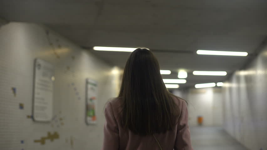 Lonely beautiful lady walking in underground walkway, crime rate, safety