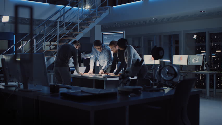 Diverse Team of Electronics Development Engineers Standing at the Desk Successfuly Solving Project Problems Late at Night, Celebrating with High Five and Cheers. Specialists Working on Design | Shutterstock HD Video #1025609567
