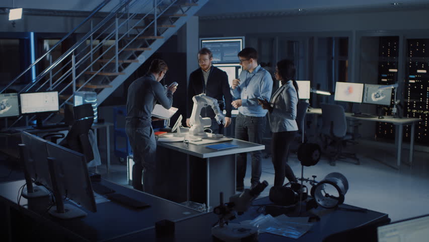 Team of Electronics Development Engineers Standing at the Desk Working on Robot Arm Prototype. Specialists Working on Ultra Modern Industrial Design, Using Machine Learning. Slow Motion | Shutterstock HD Video #1025609603