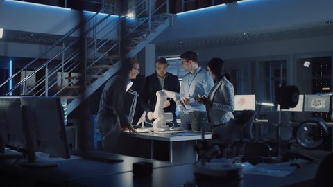 Team of Electronics Development Engineers Standing at the Desk Working on Robot Arm Prototype. Specialists Working on Ultra Modern Industrial Design, Using Machine Learning. Shot on 8K RED Camera