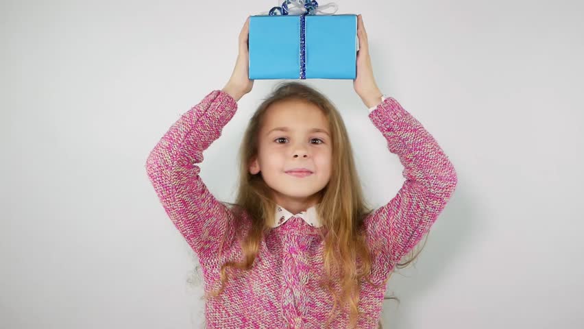 Child playfully holds the gift above the head. Slow motion
