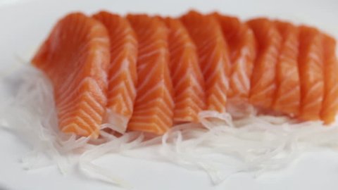 Rotated salmon sashimi on white plate