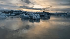 4K cinematic sunset panning right to left time lapse footage of floating icebergs at Jokusarlon Glacial Lagoon in South Iceland. 
