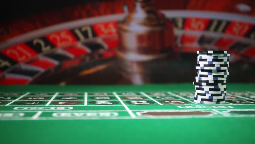 Cards and chips on green felt casino table. Abstract background with copy space. Gambling, poker, casino and cards games theme. Casino elements on green. Selective focus