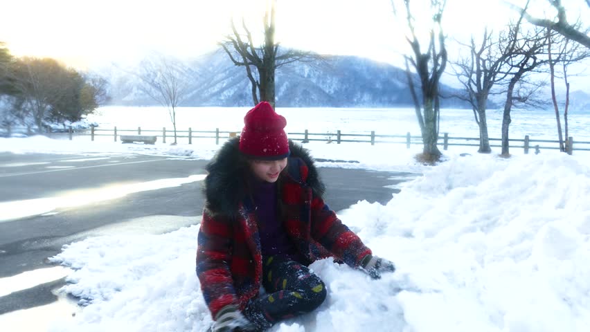 Young girl throws snowball by chuzenji lake