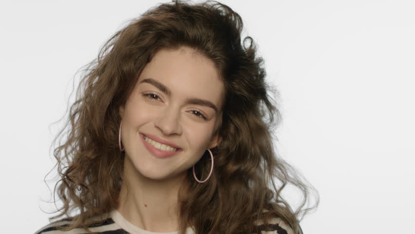 Smiling girl portrait in studio. Cheerful woman smiling face on white background. Portrait of beauty model face. Natural female beauty. Close up of happy woman smiling on camera