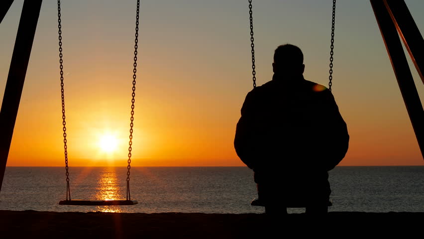 Back view silhouette of a sad man complaining alone missing his partner siting on swing at sunrise Royalty-Free Stock Footage #1025669228