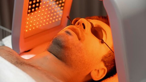 Lockdown of male face in spectacles sunbathing in facial solarium