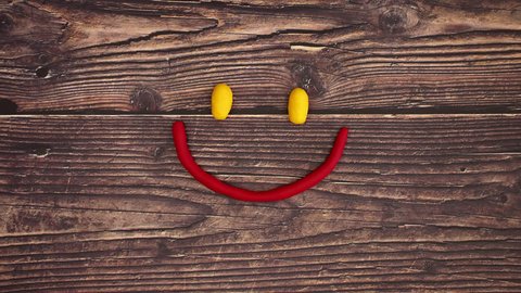 Modeling compound smiley making happy and unhappy emotions on wooden background. Stop motion animation video.  Video Stok