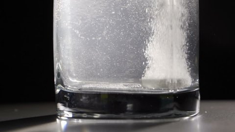 Effervescent tablet falls on a bottom of a glass