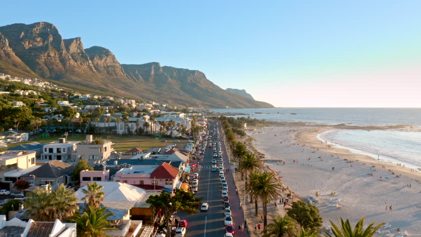 Low altitude aerial shot flying directly overhead the busy main street of Camps Bay