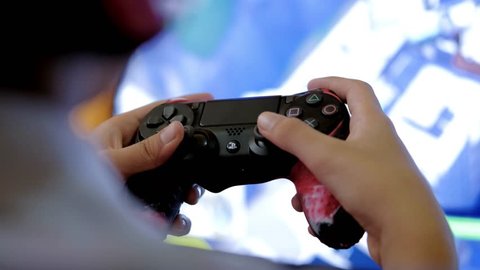 Pahang, Malaysia - March 14th 2019: Boy uses ps4 controller to play video game on PlayStation 4. The PlayStation 4 (PS4) is an eighth-generation home video game console developed by Sony Interactive.