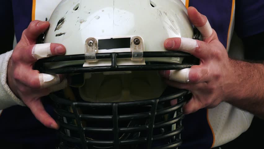 american football player holding helmet 
