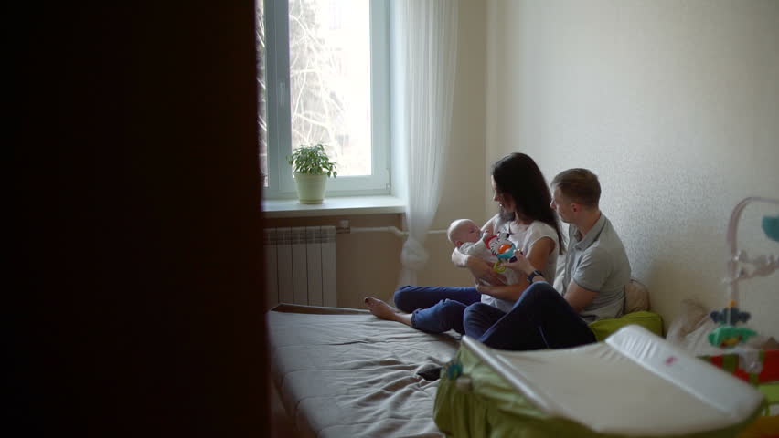 Man and Woman with Baby on her Arms are Talking | Shutterstock HD Video #1025713280