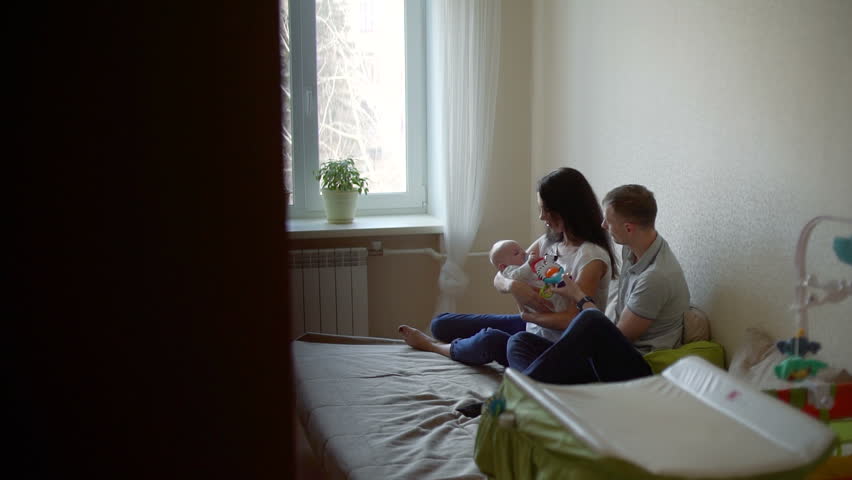 Young Man and Woman Talking and Playing with Baby | Shutterstock HD Video #1025713289
