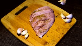chicken breast for diet on a wooden Board. the garlic and the knife, the song of spring