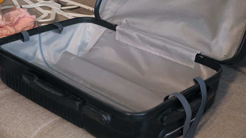 girl packing travel suitcase at home, close up