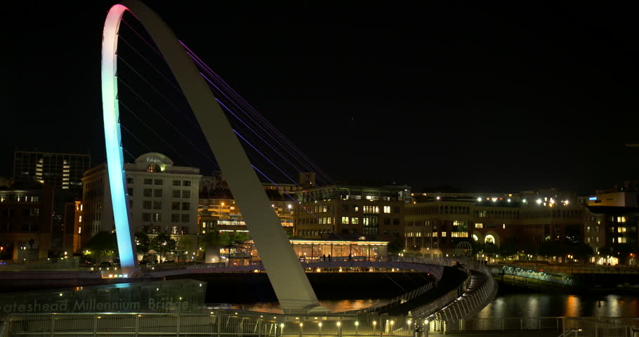 Timelaspe of Newcastle Gateshead Bridge at night with lights changing colour and city lit in the background