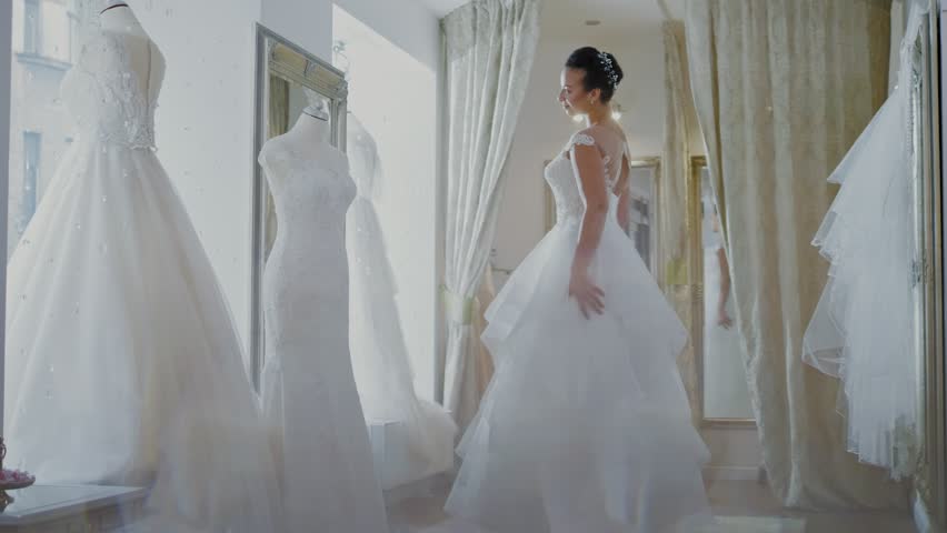 Beautifu bride choosing wedding dress in a wedding salon