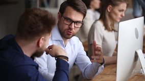Two male colleagues employees cooperating in office talking working together at workplace, smiling businessmen coworkers discussing planning computer business project brainstorm in corporate teamwork - Powered by Shutterstock - Get 15% off with code: PIKWIZARD15
