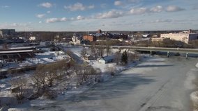 river covered with ice and a road bridge from above, shooting from a drone