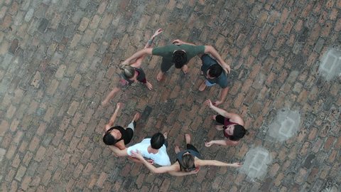 Circle of friends, above view of social group hugging each other, feeling happy and united.